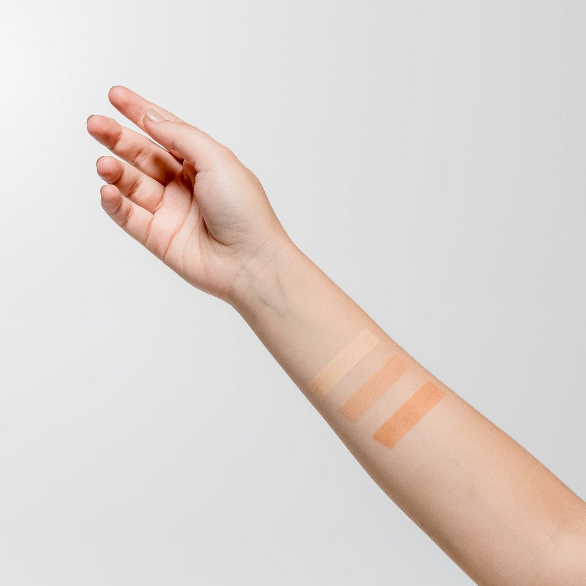 Polvo Suelto Facial Natural de Aruná en la brazo de una mujer.