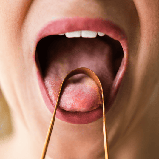 una mujer usando nuestro raspador de Lengua en cobre