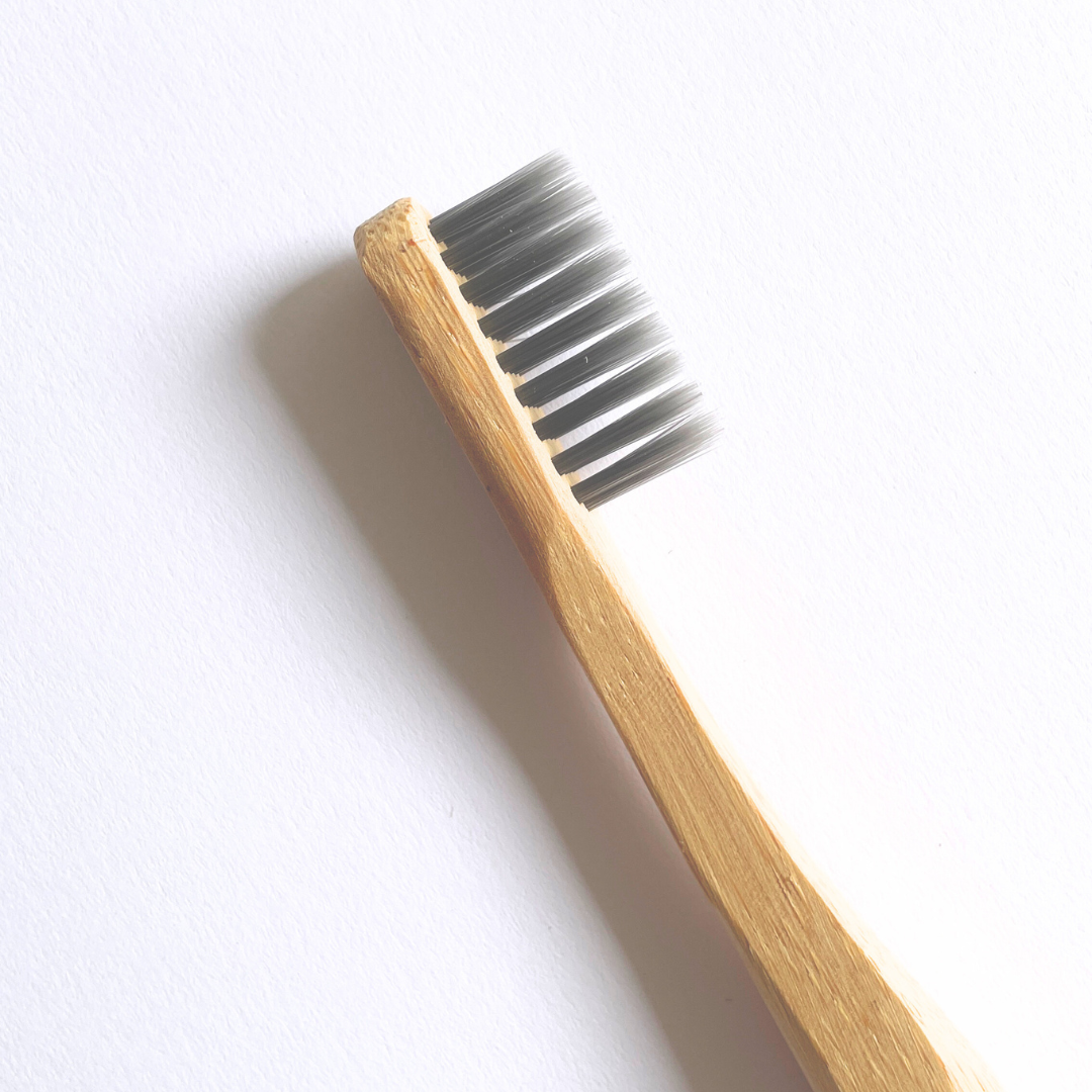 cerca la cabeza de cepillo de dientes de bambú para niños de la marca soul seed con fondo plano