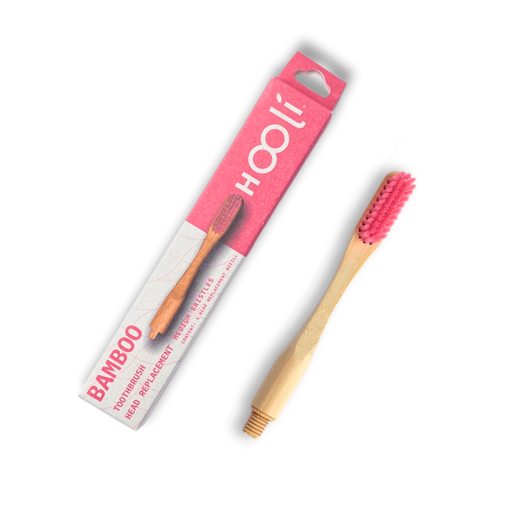 Repuesto de cepillo de bambu color rosada a lado su caja con fondo blanco