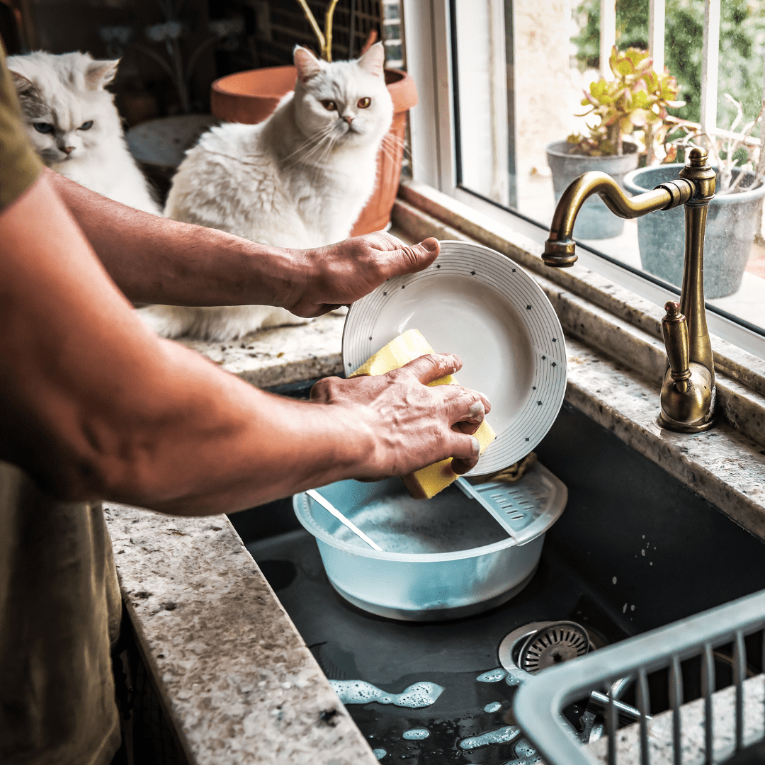 una chico lavando la loza con el Lavaloza Líquido 500ml de Biogar
