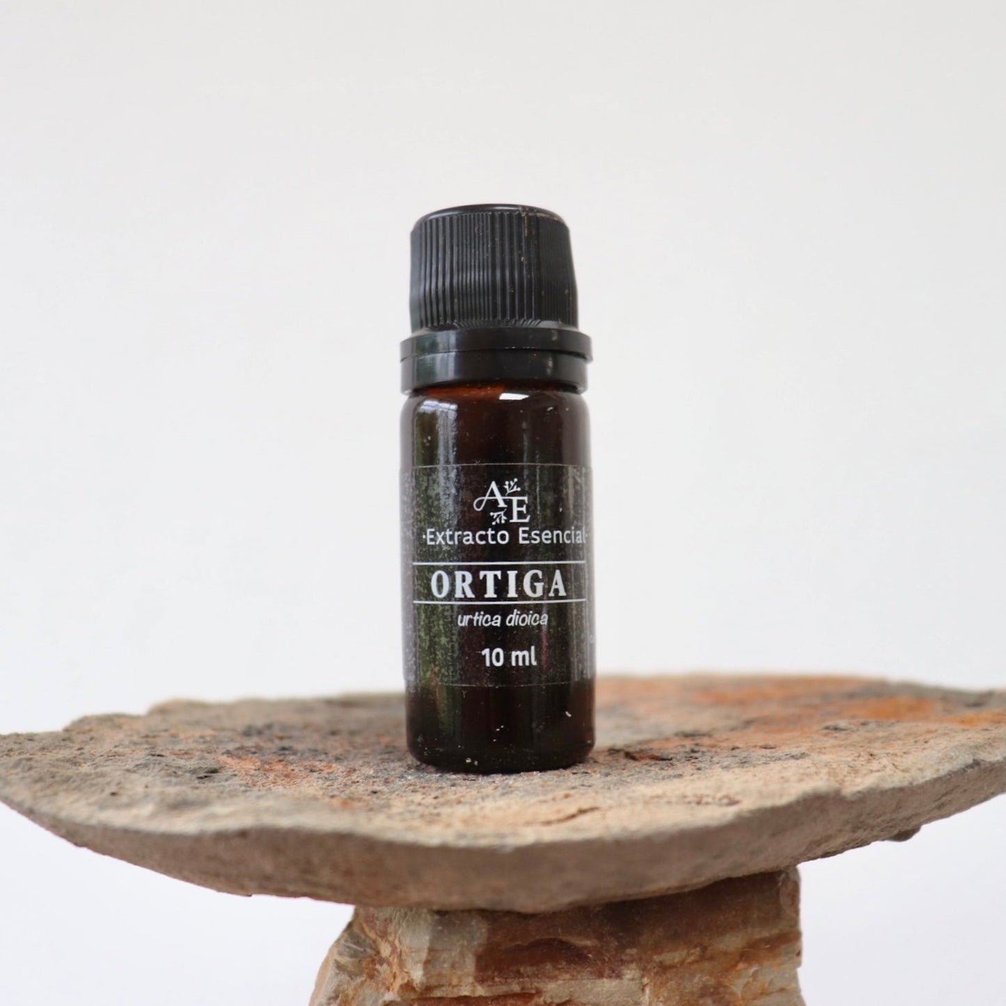 Extracto de ortiga de Ananda encima una piedra con fondo blanco