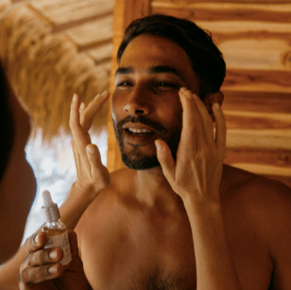 hombre usando el Sérum Facial Rejuvenecedor Q10 de Coco Salvaje