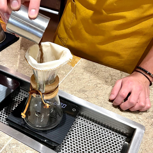 un chico preparando café usando filtro para café en tela reutilizable de chemex