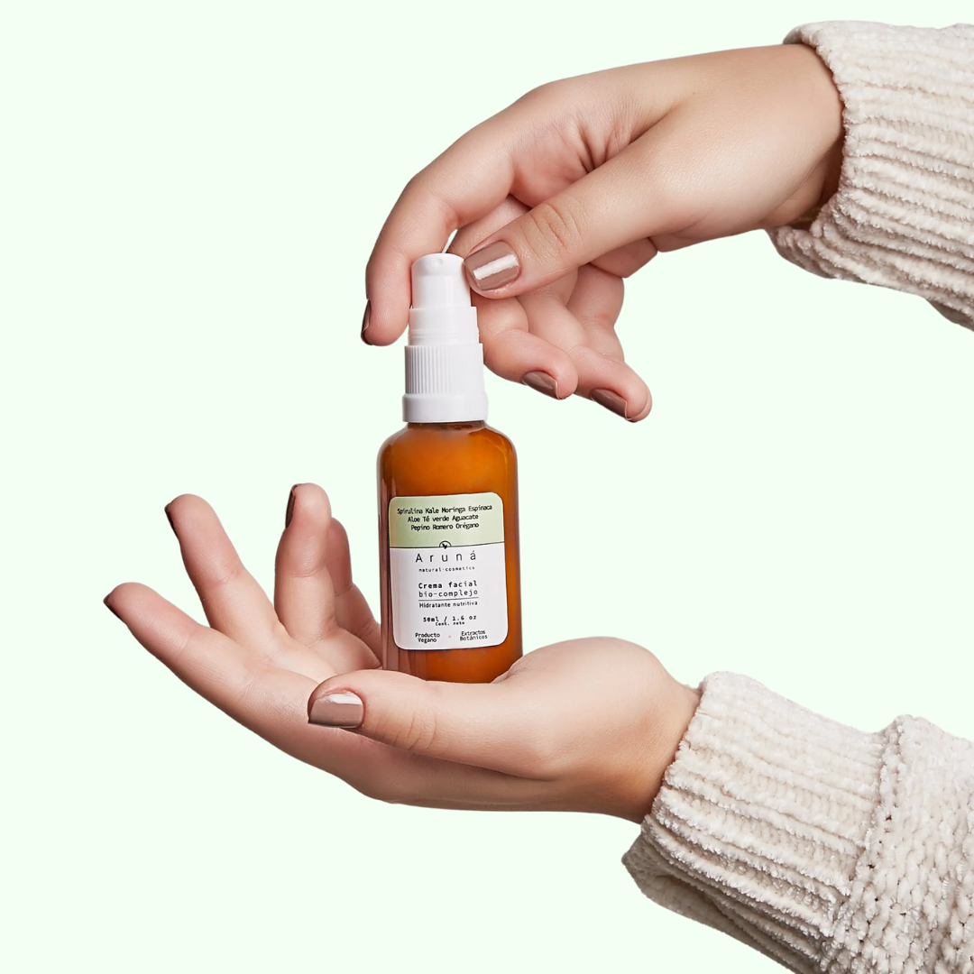 crema facial bio complejo de aruna en los manos de una mujer 