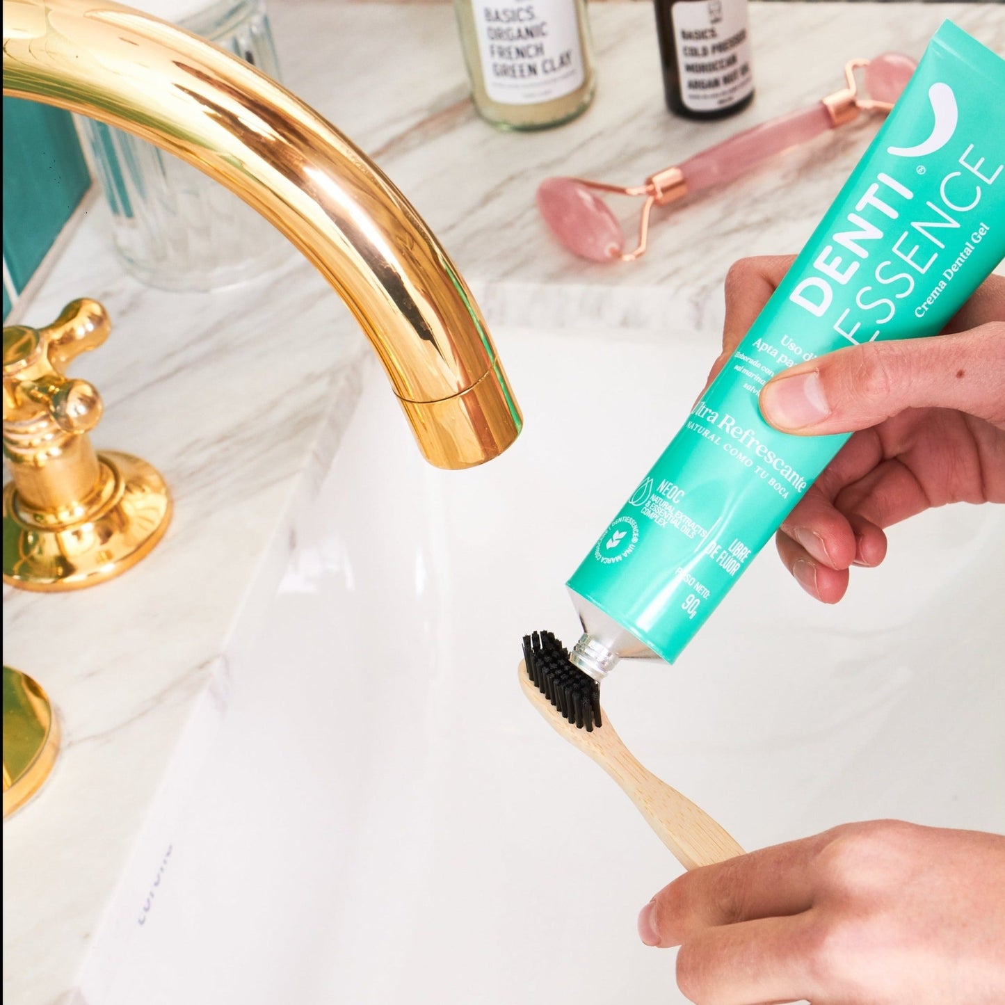 una mujer usando la crema dental sin flúor y un cepillo de bamboo