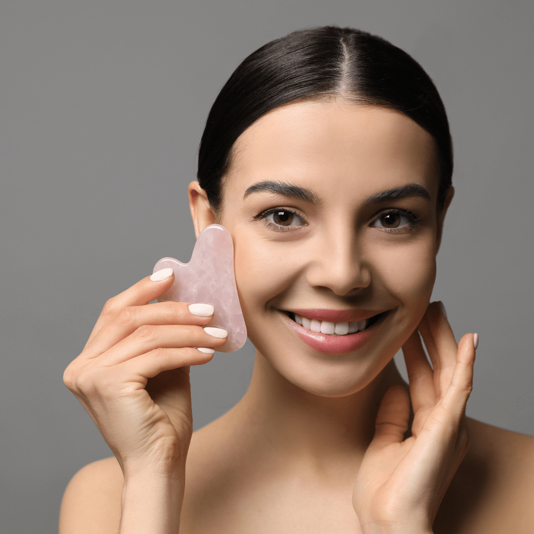 una mujer usando una gua sha en su cara
